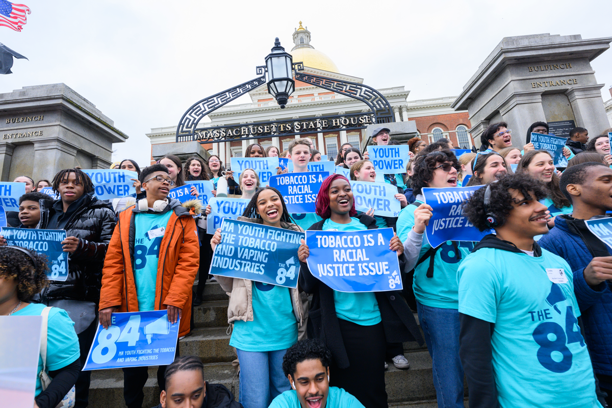 Group of students at ENUFF day outside of the State house, holding signs saying 